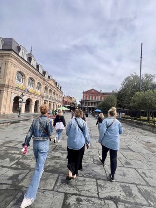 Friends strolling a French Quarter plaza in matching denim
