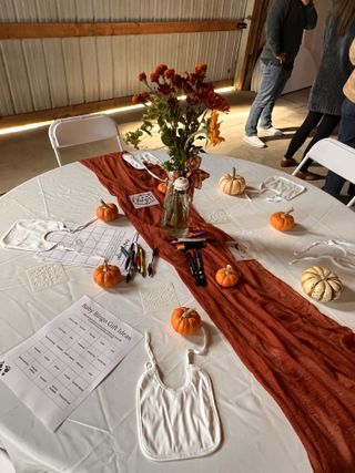 Autumn baby shower table with mini pumpkins and rust runner