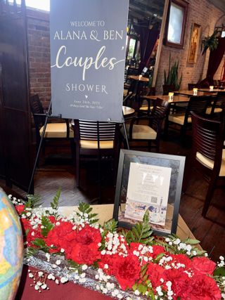 Couples' shower welcome sign with red carnation arrangement