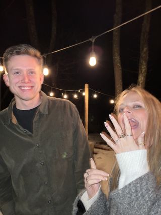 Newly engaged couple beneath winter string lights