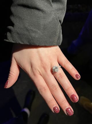 Close-up of a halo engagement ring on a bride-to-be's hand