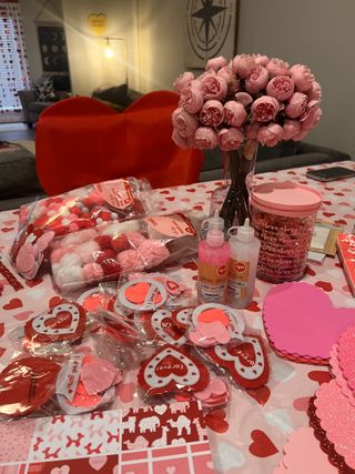 Valentine's craft party table with heart favors and pink peonies