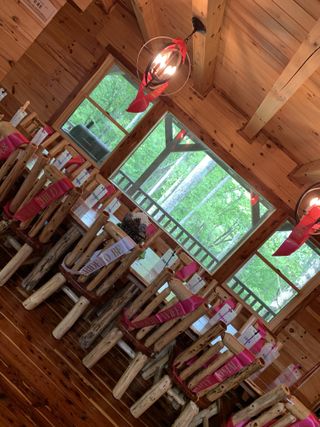 Rustic wood-beamed ceremony space with pink-ribboned chairs
