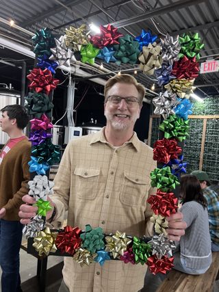 Smiling guest holding a giant bow-covered photo frame